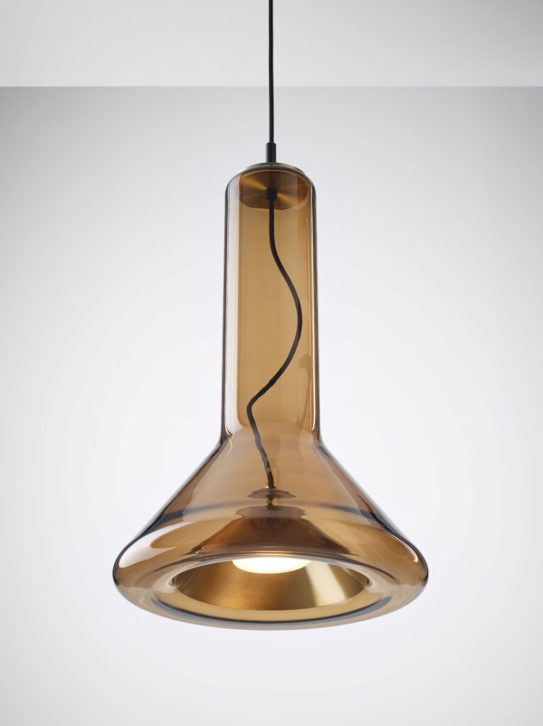 Brokis Whistle Medium Pendant with handblown brown glass in a flask form, exposed bulb, and black flex, set against grey.