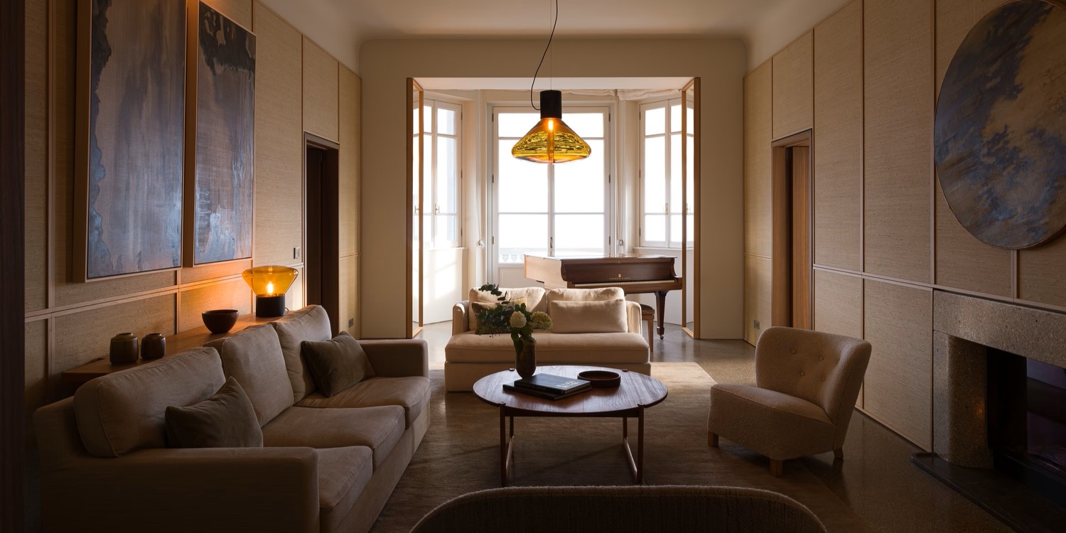 Brokis Muffins pendant in a chic living room with beige sofas, and sculptural art. Sunlight streams through windows.