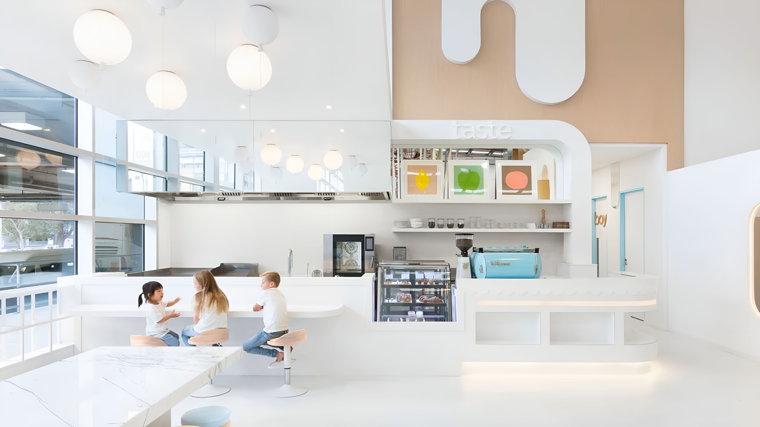 A luminous, modern café with white interiors. Three children sit at a curved counter beneath Brokis Memory ceiling lights.