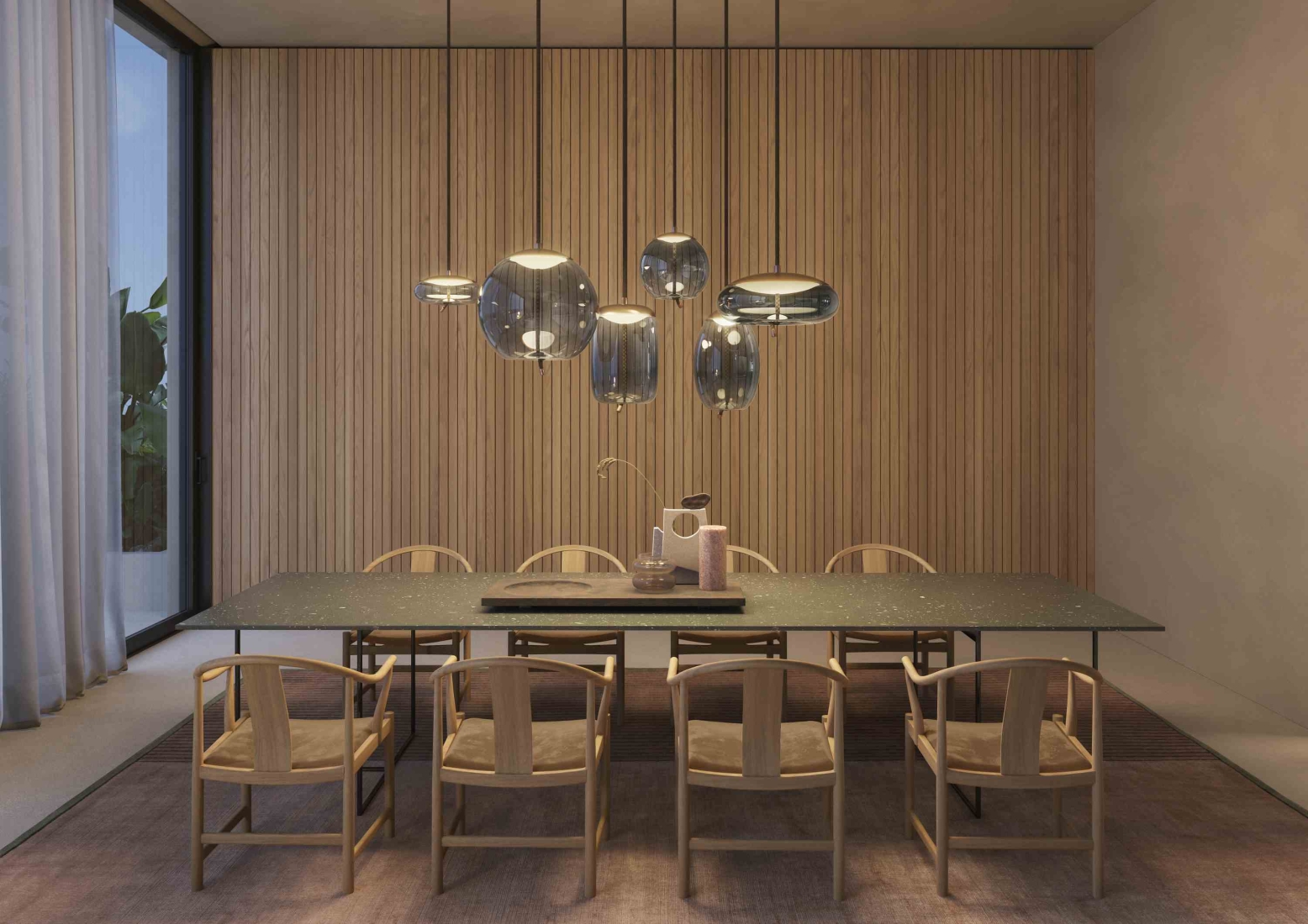 A modern dining room with a long dark table, eight curved wooden chairs, Brokis Knot pendants overhead.
