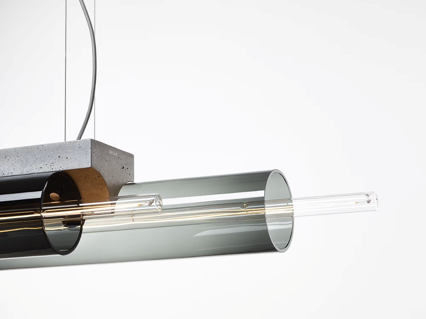 A sustainable Brokis Overlay chandelier with handblown glass, grey concrete block, and a linear bulb, suspended elegantly.