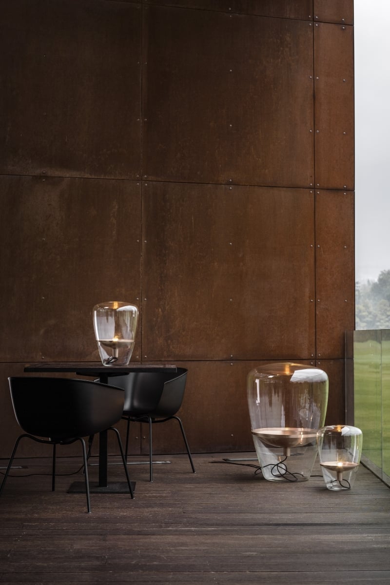 Brokis Balloons on a wooden deck with a rusted metal wall, black bistro set.