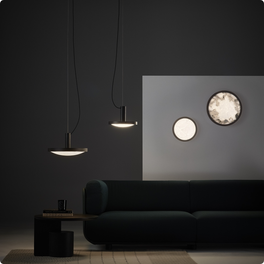 Brokis Convex lights in a luxurious living room with dark walls and a plush green sofa.