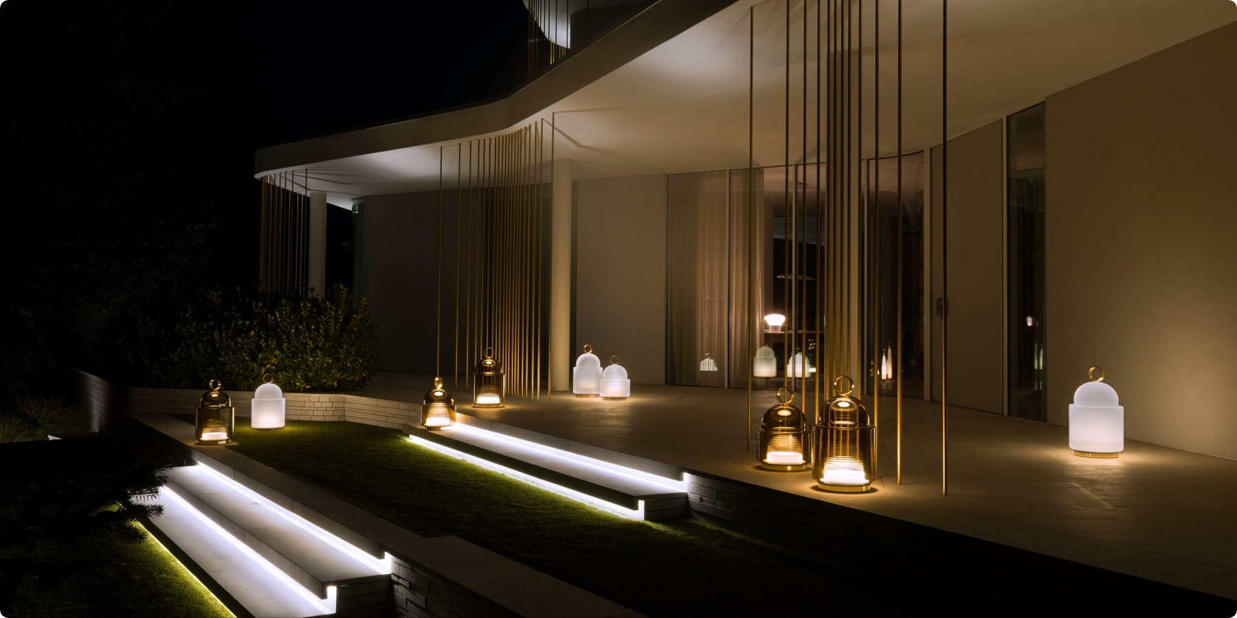 Brokis Dome Nomad lanterns illuminates sleek outdoor steps, in front of a modern building at night.