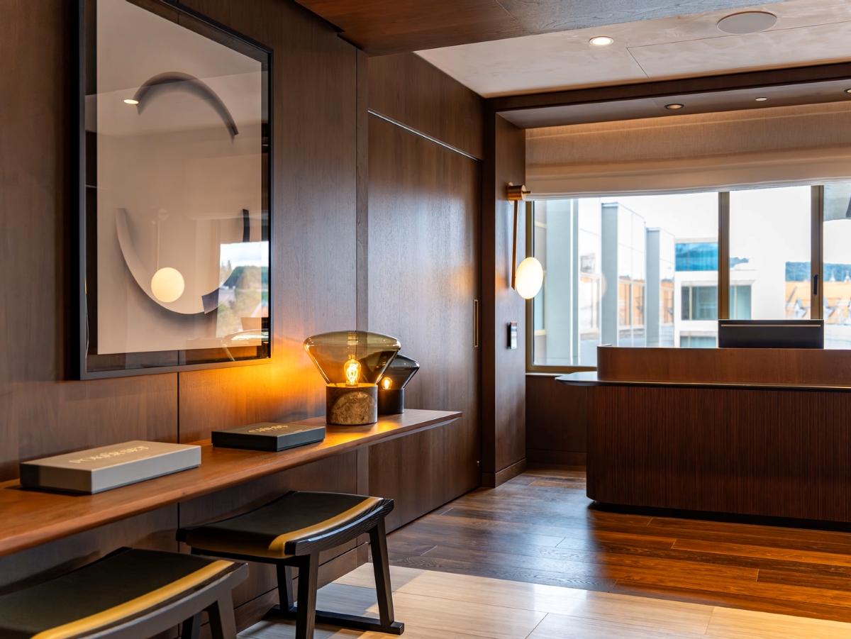 A contemporary, warmly lit reception with wood-panelled walls, Brofis Muffins table lamps, and luxe modern decor.