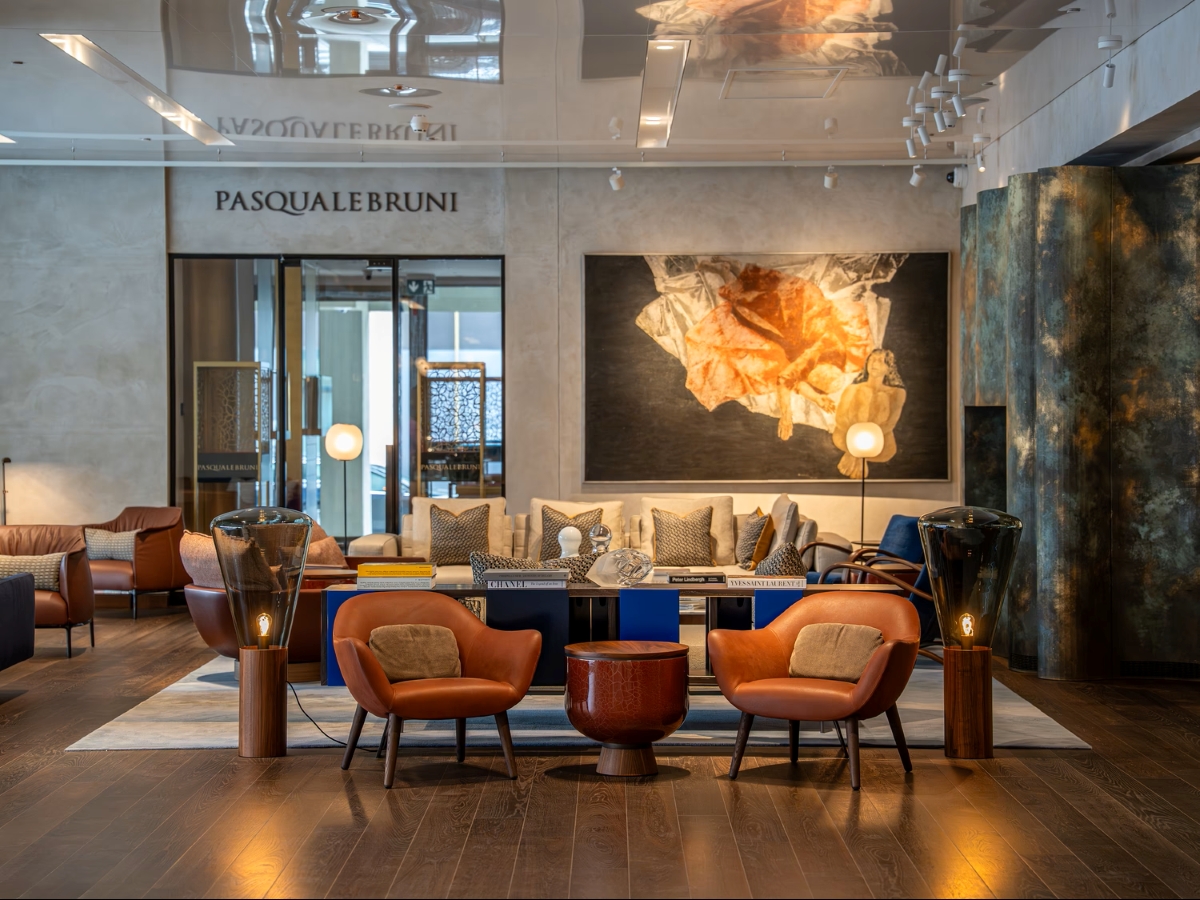 A lounge with leather chairs, round table, sofa, rich art, Brokis Muffins 04 Floor lamps and elegant contemporary décor.