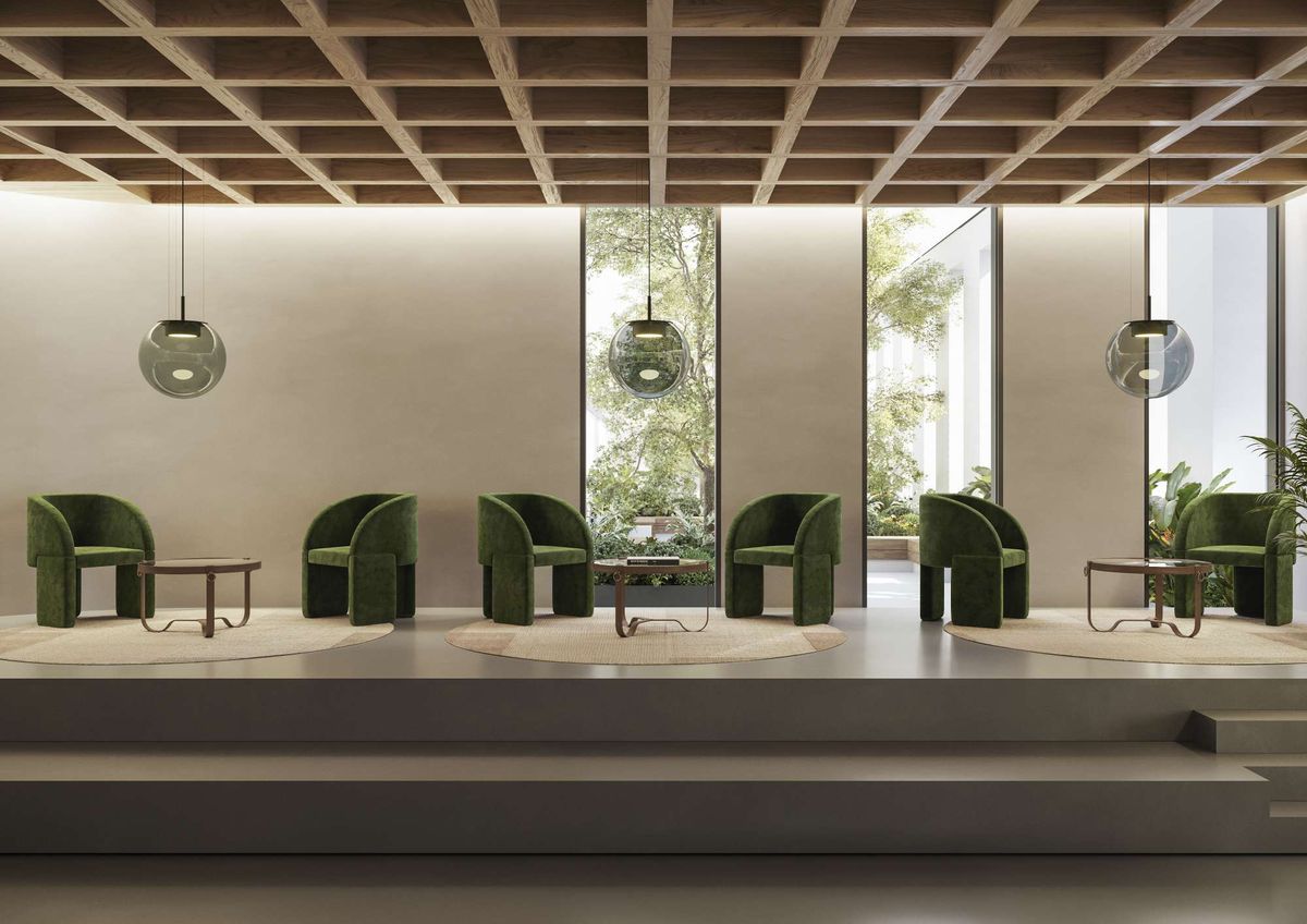 A modern, minimalist lounge with green velvet chairs, Orbis pendant lights, and wood accents overlooking lush greenery.