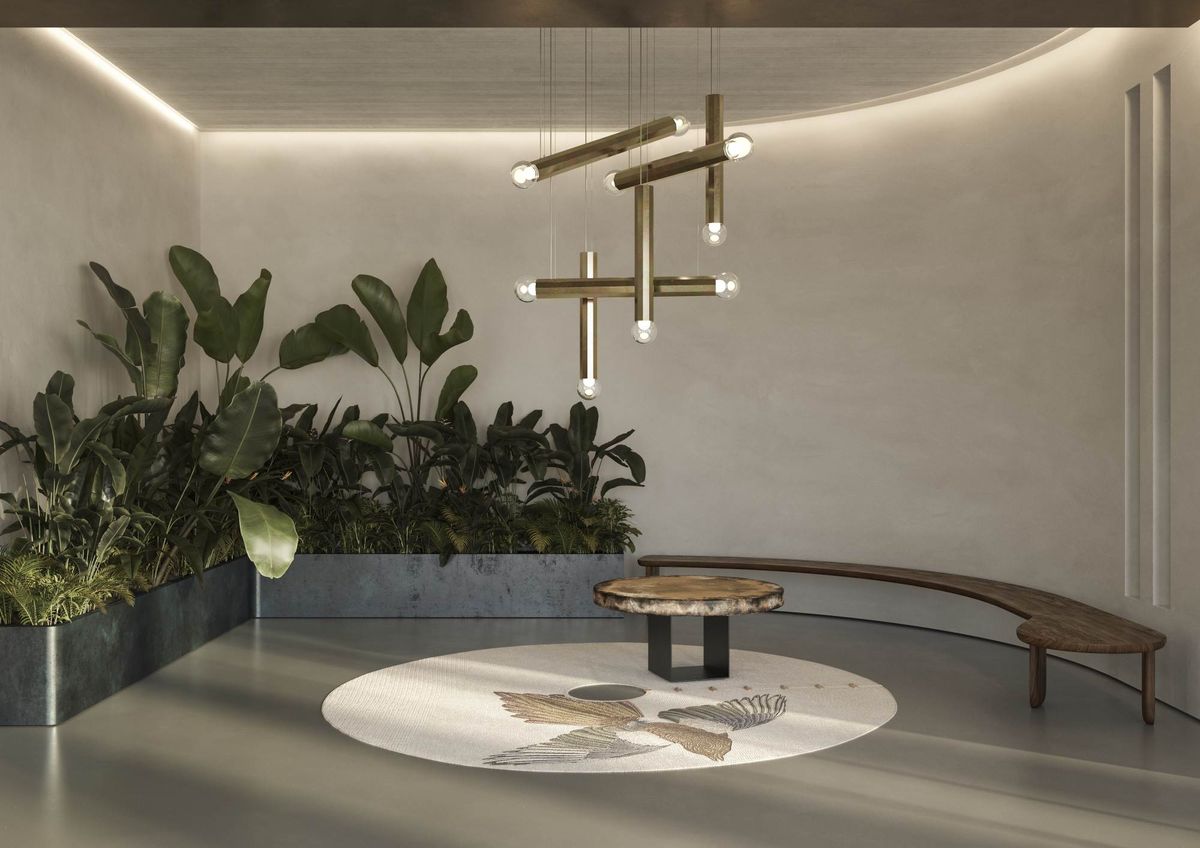 A modern minimalist lobby with, lush green plants, a patterned rug, round stone table, curved bench, Prisma pendants.