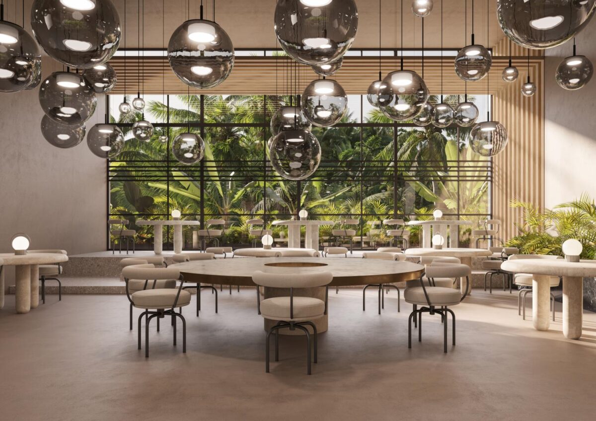 Elegant restaurant with round tables, white chairs, Brokis Orbis pendants, and palm-framed window views.