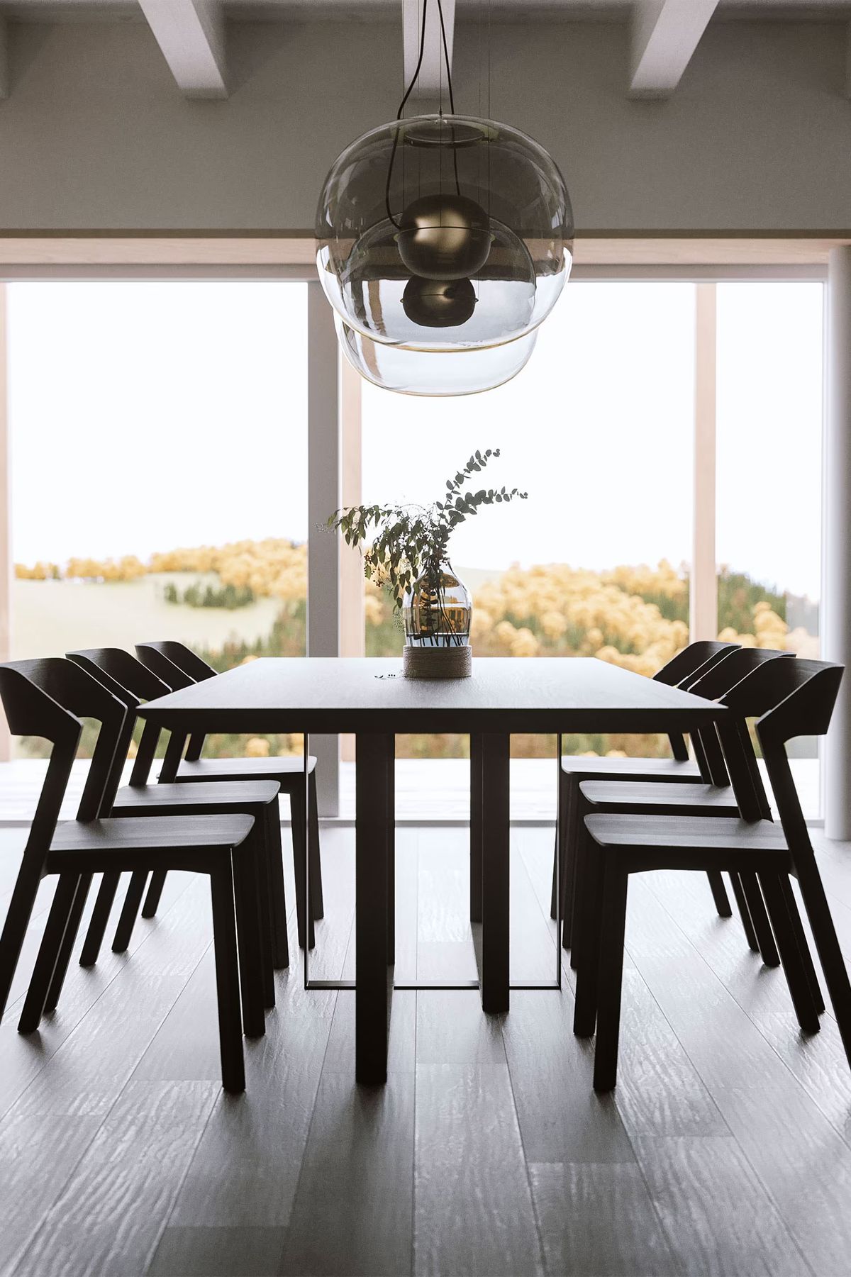 A dining room with Brokis Big One Large Pendants, sleek black chairs, and sunlit views through floor-to-ceiling windows.