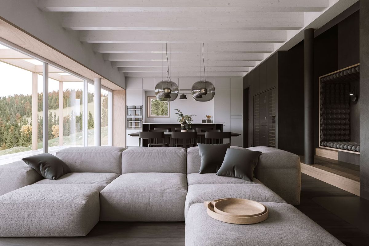 A luxurious living room with a grey sectional sofa, designer accents, and Big One Large pendants. Forest views beyond.