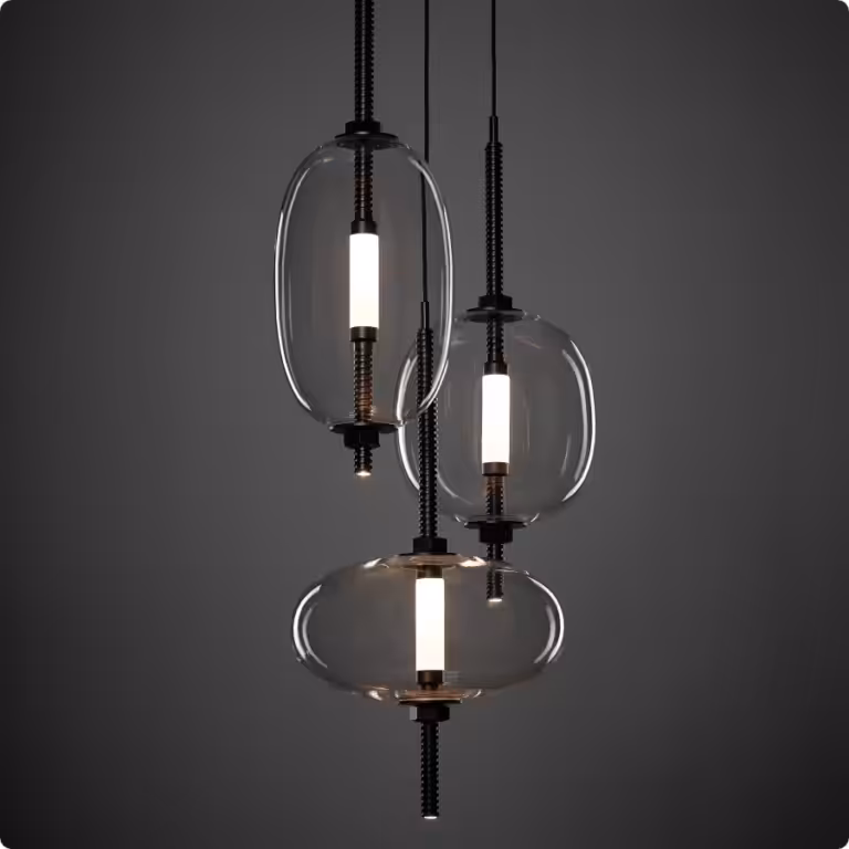 Brokis Under Pressure Pendants feature elongated glass shades with sleek black and metallic accents on a dark backdrop.