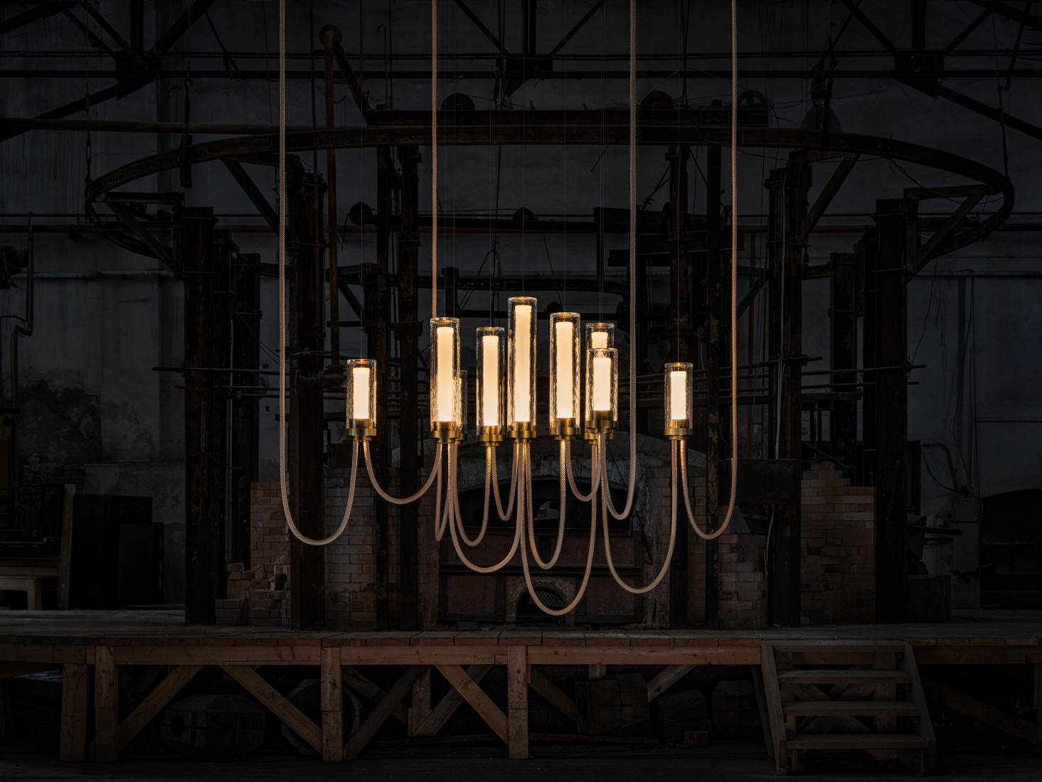 Brokis Arcade Criss-Cross Large IX Chandelier in transparent glass with ripples and brushed champagne finish in industrial interior.